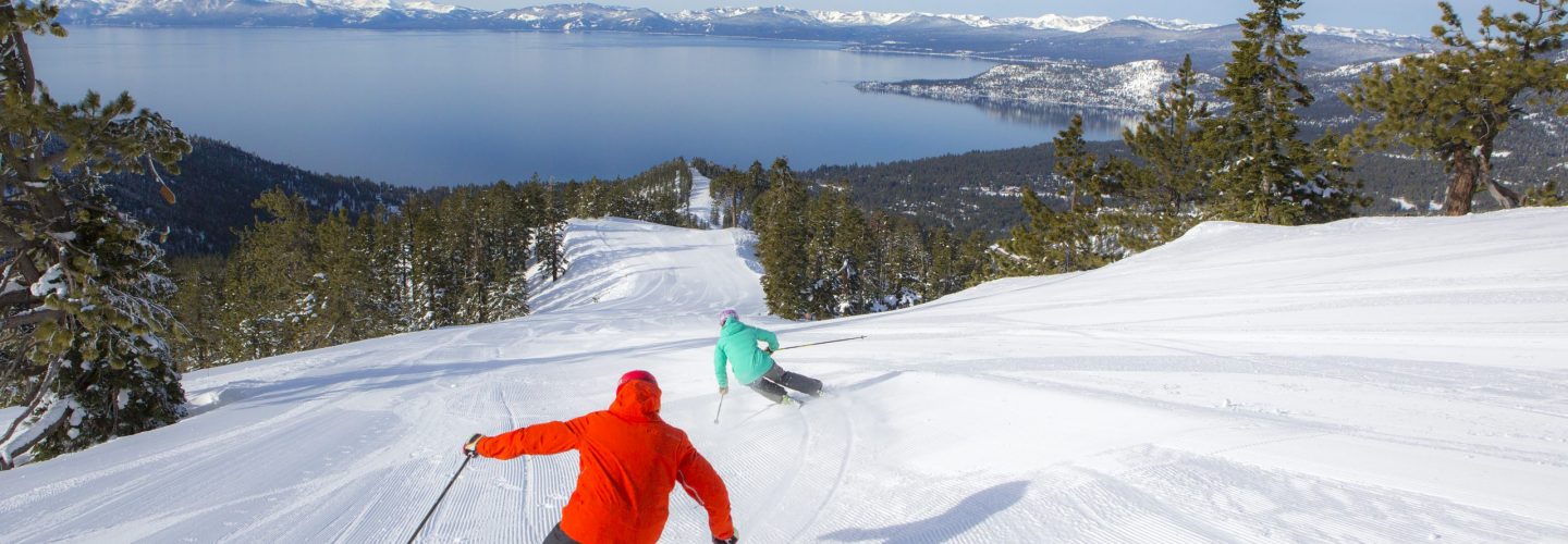 Skiers on ski run at Diamond Peak with view of Lake Tahoe