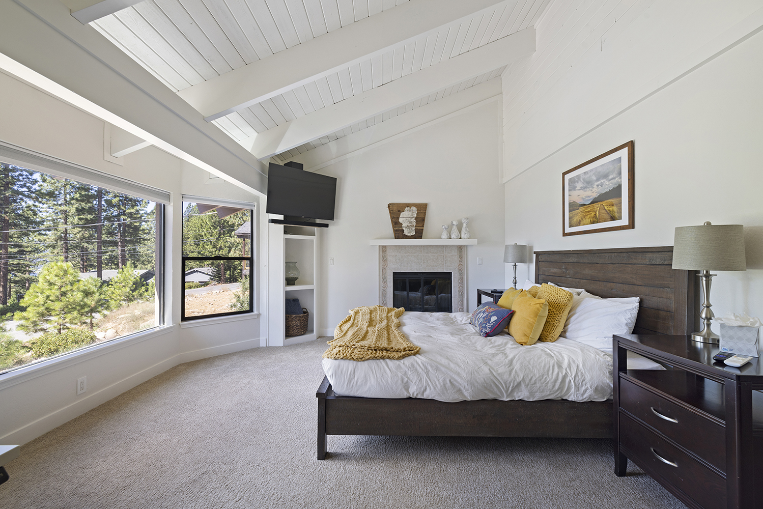 Spacious primary bedroom with fireplace, Cal King bed and view of Lake Tahoe at Tahoe vacation rental