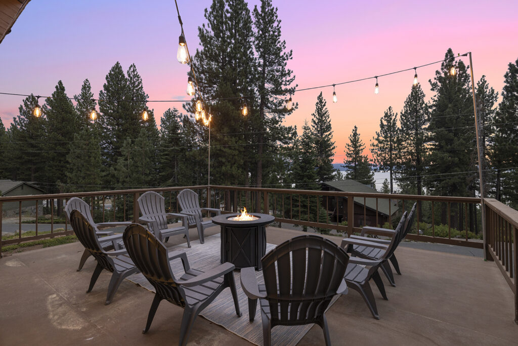 Patio with fire pit and view of Lake Tahoe in the evening at Tahoe vacation rental